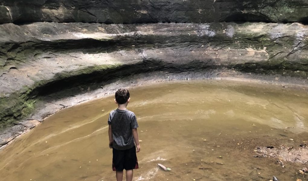 Boy contemplating cave water cavern Starved Rock solitary lonely