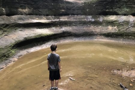 Boy contemplating cave water cavern Starved Rock solitary lonely