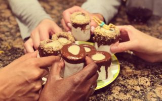 Hands holding shots together cheers marshmallow s'mores shooters