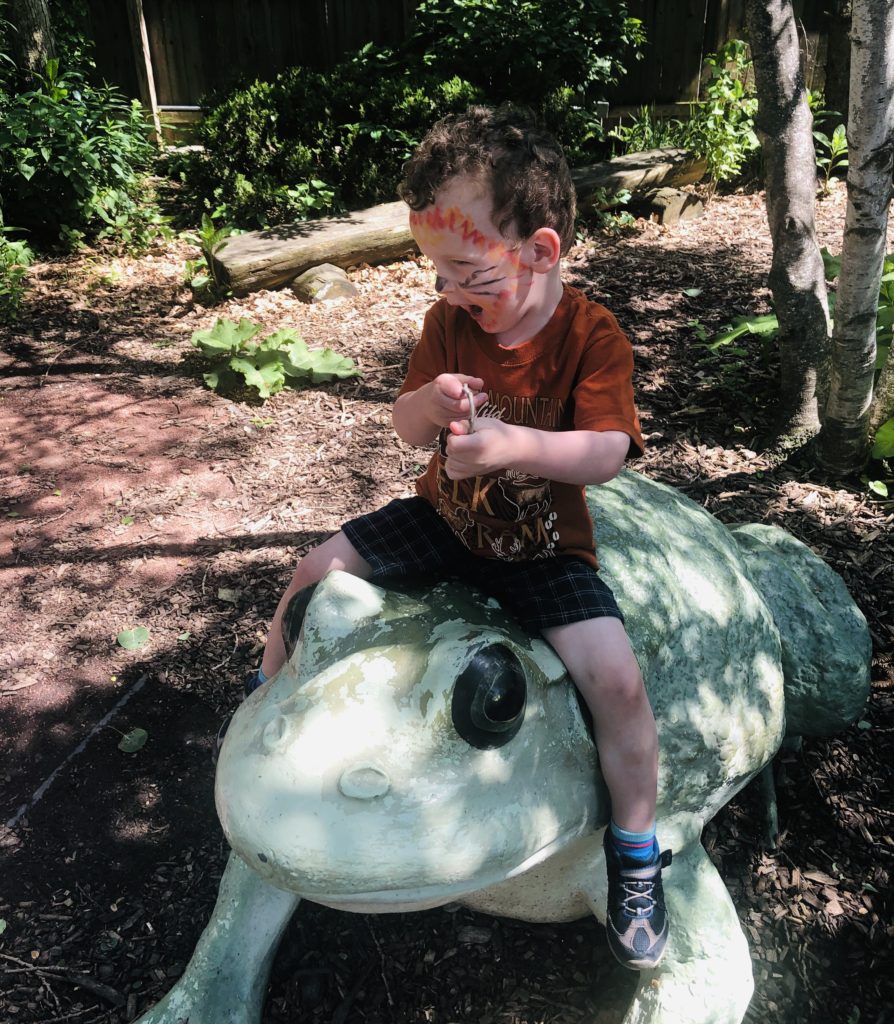 Toddler on garden statue frog Hamill Family Play Zoo Brookfield Zoo